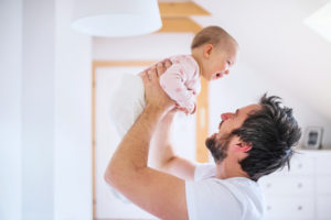 Ordentliche Kündigung Elternzeit, rechtmäßige Kündigung in der Elternzeit, Kündigung Elternzeit, Mann hält Baby auf dem Arm